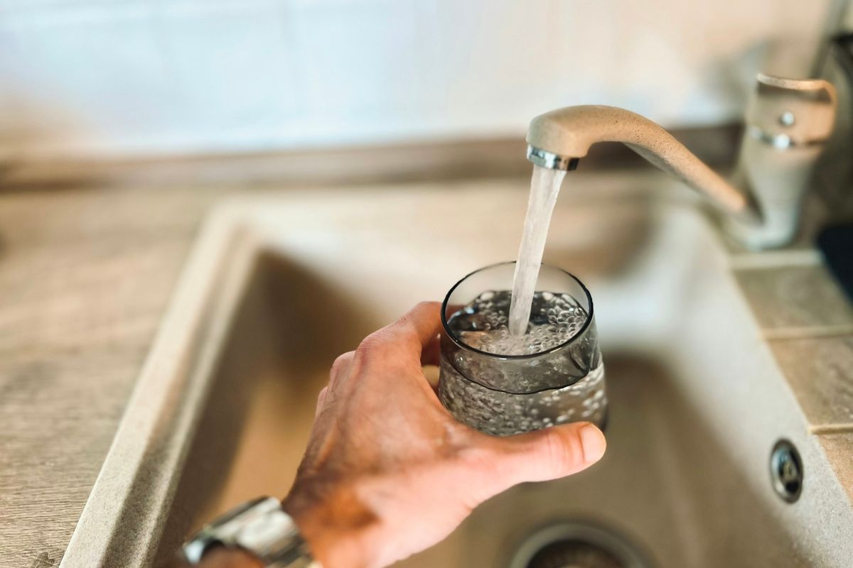Filling a glass with water from a kitchen faucet